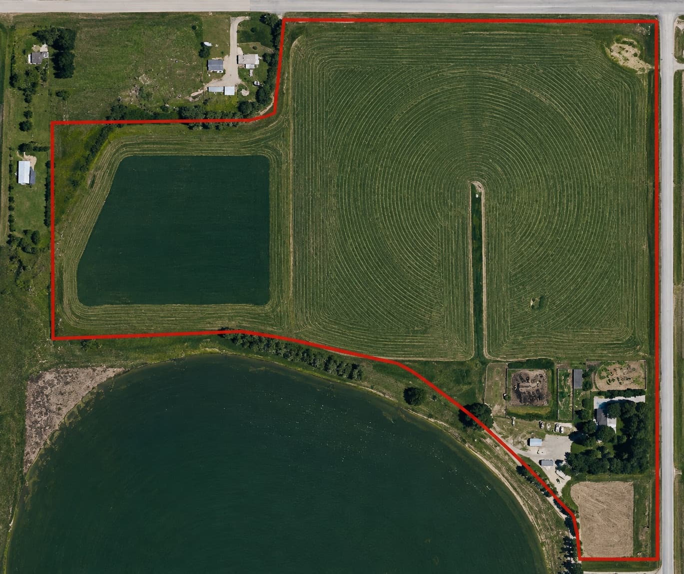 Aerial view of the McLennan lands near Medicine Hat, cultivated fields outlined in red with a reservoir along the southern boundary.